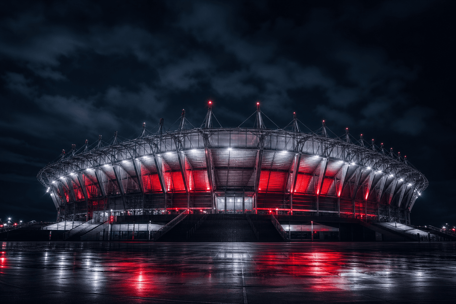 Night stadium exterior lit with red and white floodlights